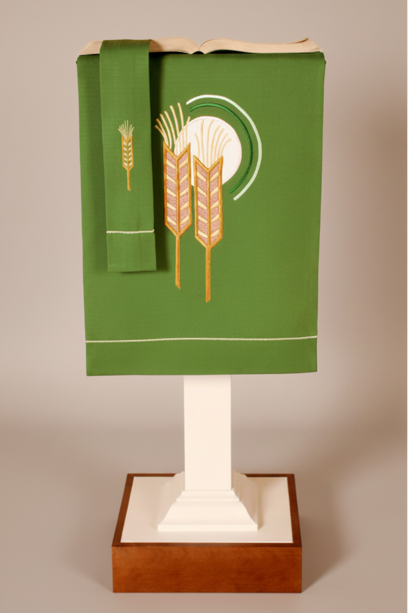 Green祭坛布料装饰品,上面有麦穗图案,放在一个木制底座上。Altar fabric ornament with wheat ears pattern on a wooden base.