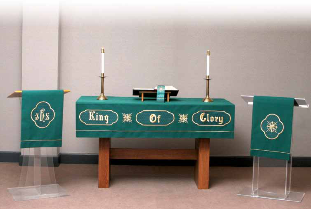 Altar with green fabric, candles, and religious text in a church setting